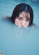 A young woman swimming in a pool of water.