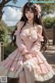 A woman in a pink dress sitting on a wooden bench.