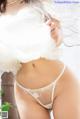 A woman in a white lingerie posing for the camera.