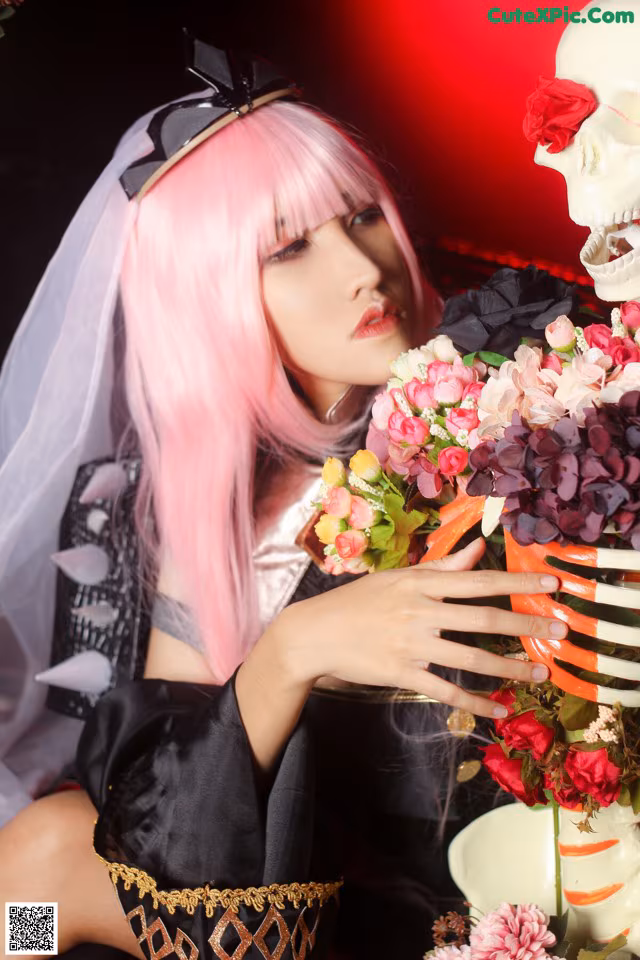 A woman with pink hair holding a bouquet of flowers.