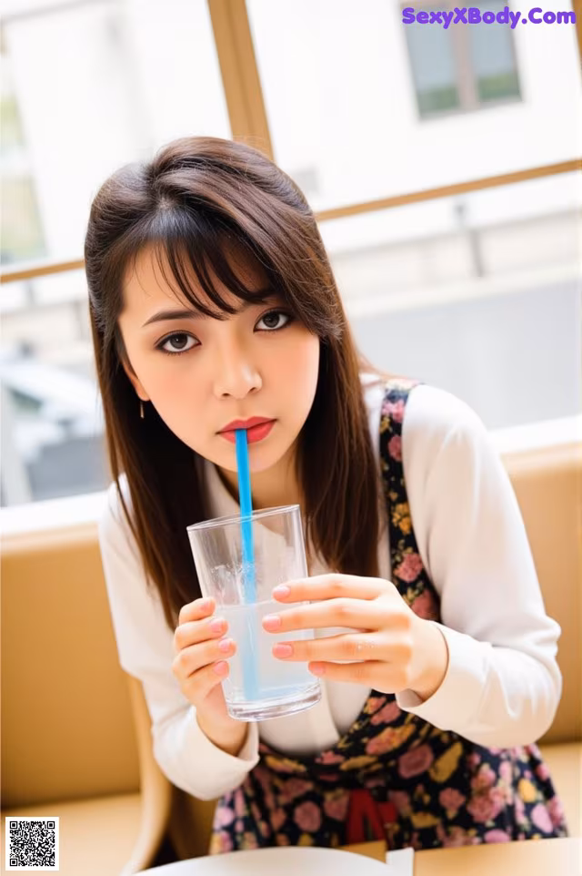 A woman sitting at a table with a glass of water.
