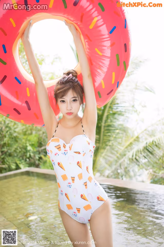 A woman in a bathing suit holding an inflatable ring.