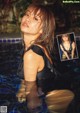 A woman in a black bathing suit standing in a pool.