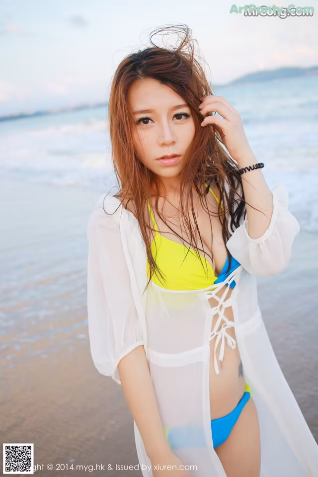 A woman in a bikini standing on a beach.