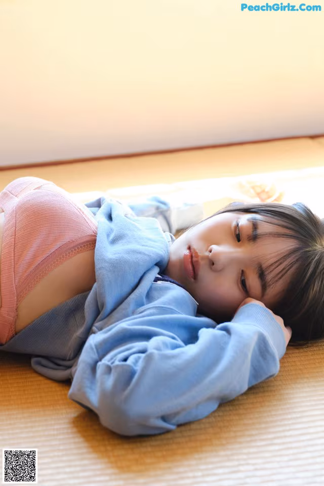 A little girl laying on the floor with her eyes closed.