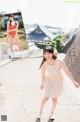 A woman in a bathing suit is walking down the street.