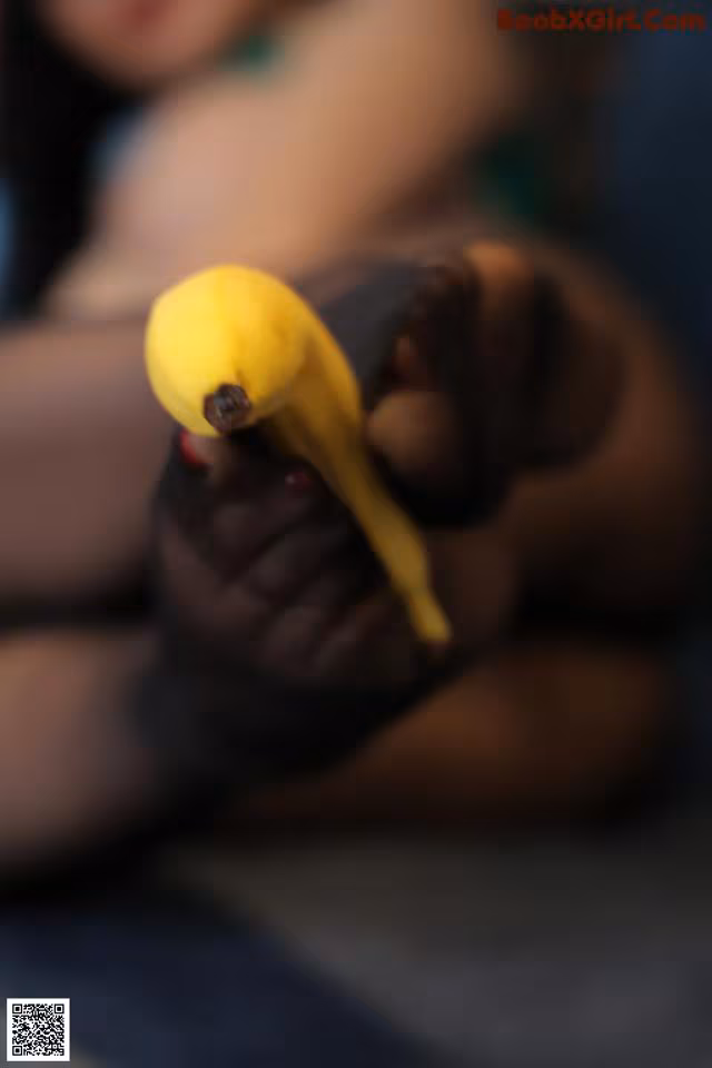 A woman holding a banana in her hand.