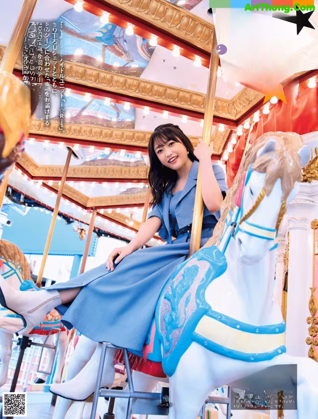 A woman sitting on a carousel with a horse.
