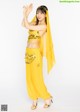 A woman in a yellow belly dance outfit posing for a picture.