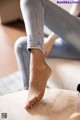 A woman sitting on a couch with her feet up on a table.