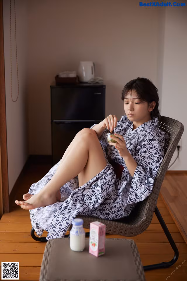 A woman sitting in a chair with her legs crossed.