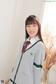 A woman in a school uniform posing for a picture.