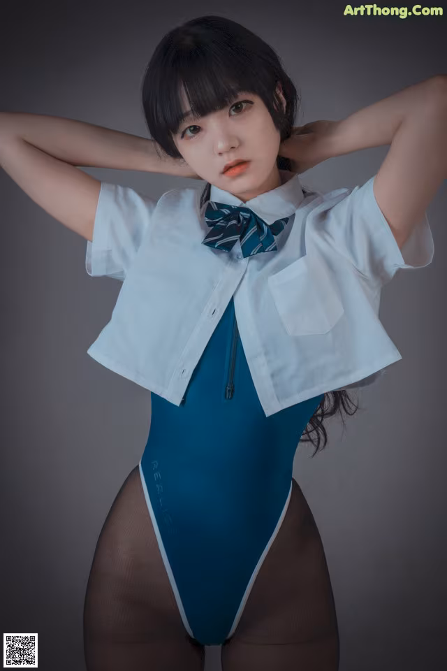 A woman in a blue bodysuit and a white shirt.