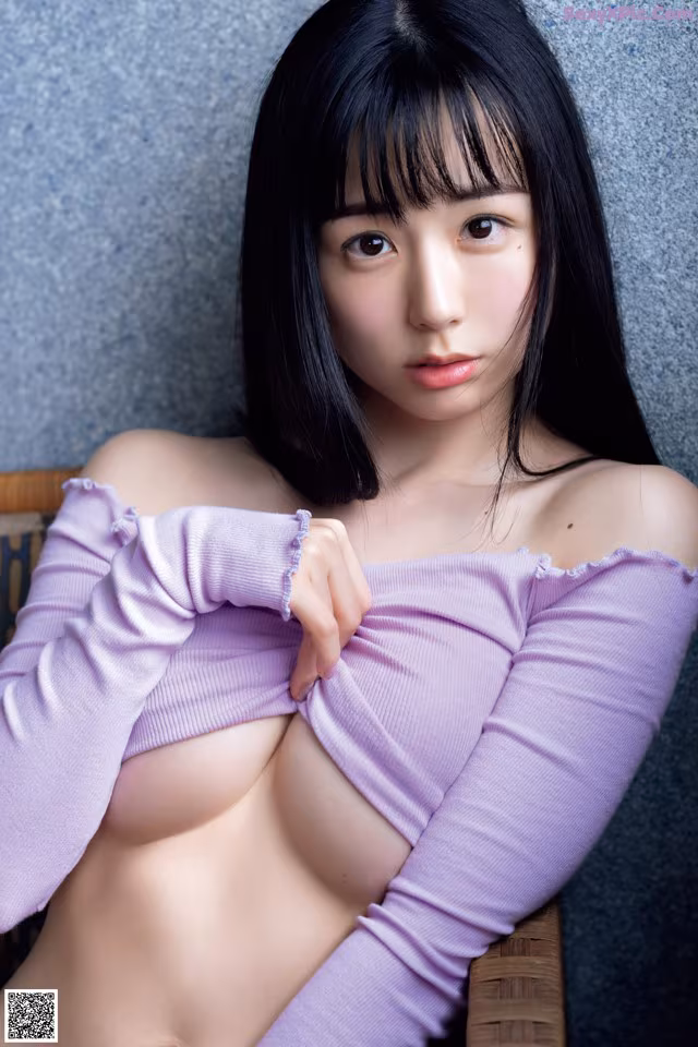A woman in a purple top is posing for a picture.